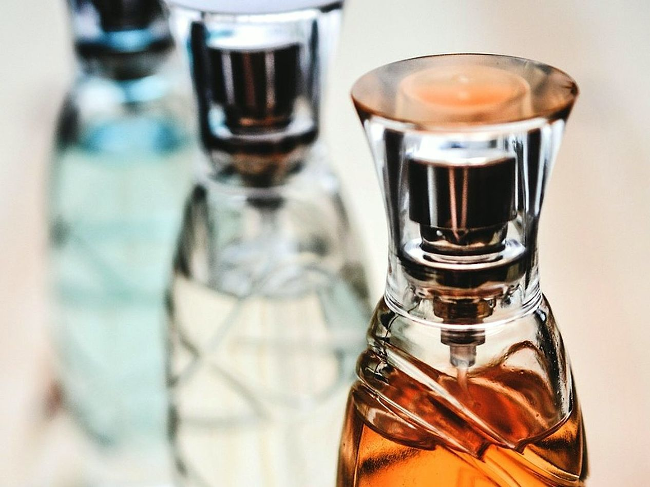 Uma coleção de frascos de perfume dispostos sobre mármore